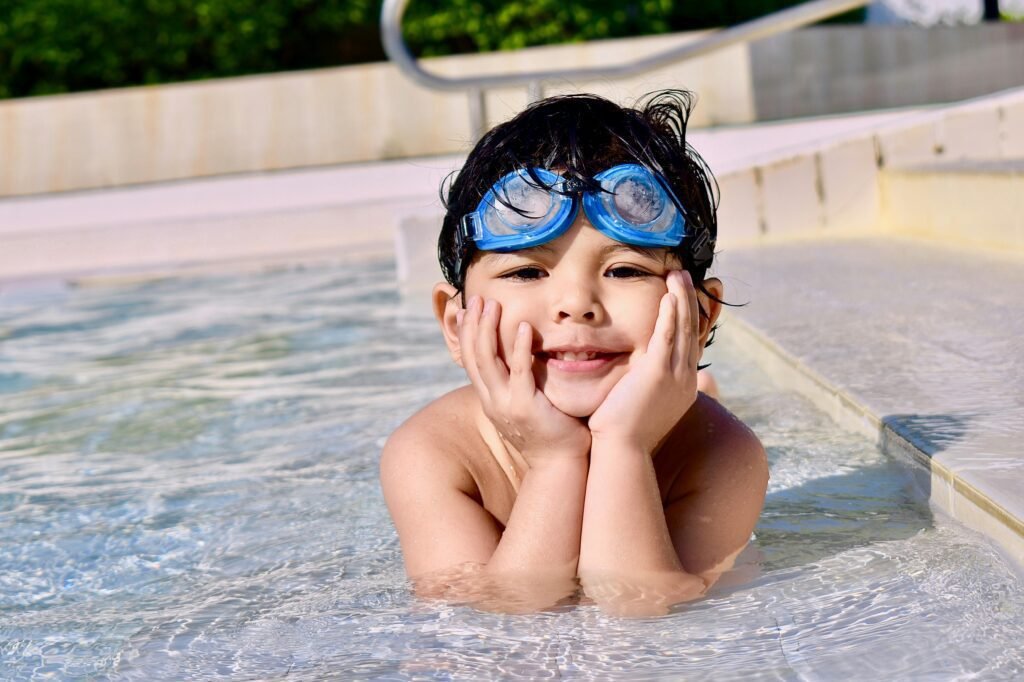 niño sonriendo en una piscina